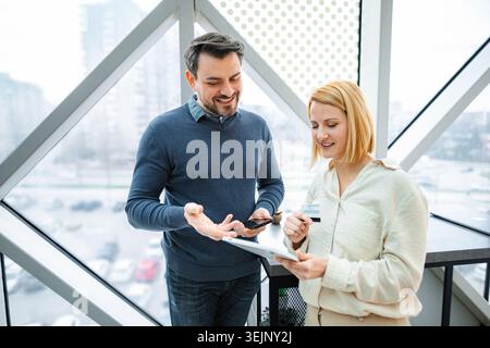 Two business colleagues shopping online with a credit card and digital tablet Stock Photo