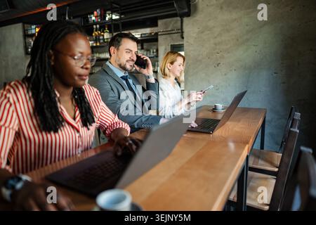 Diverse business people working remotely in cafe Stock Photo