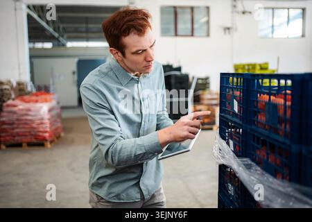 Warehouse worker checking inventory using digital tablet Stock Photo