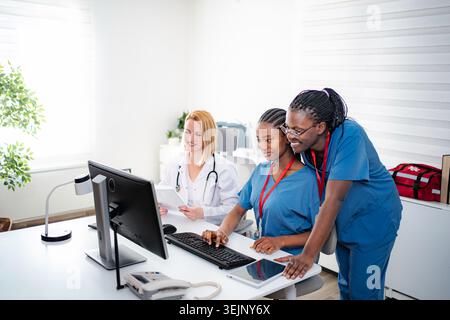 Medical team collaborating on computer in clinic office Stock Photo