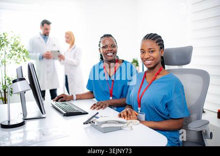 Diverse medical team collaborating in modern clinic office Stock Photo