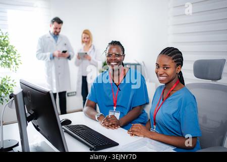 Two smiling female nurses working in hospital office Stock Photo