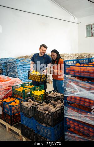Farm workers checking fresh vegetable inventory in warehouse Stock Photo