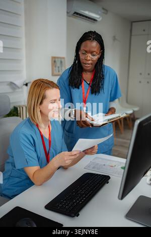 Healthcare professionals collaborating on documents in medical office Stock Photo