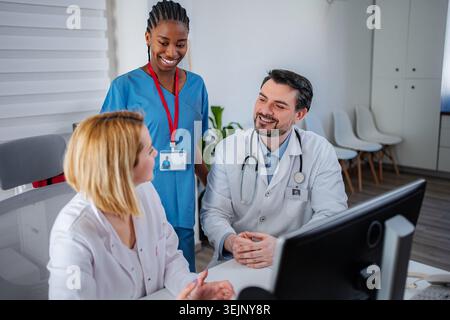Diverse medical team collaborating in clinic discussing patient care Stock Photo