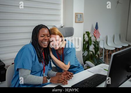 Diverse female medical coworkers laughing having fun together Stock Photo