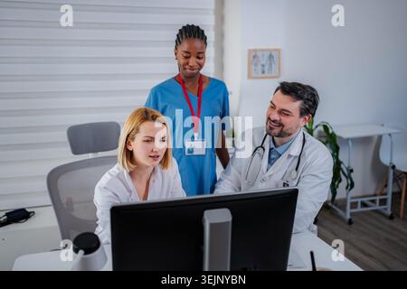 Medical professionals collaborating on computer in clinic office Stock Photo