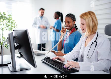 Diverse medical team working in busy modern hospital office Stock Photo