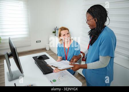 Nurses discussing patient files in hospital office Stock Photo