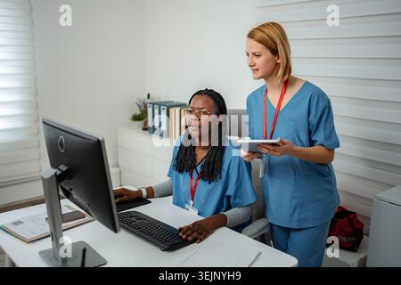 Medical professionals collaborating on computer and digital tablet Stock Photo