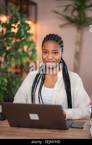 Young black woman smiling while working on laptop Stock Photo
