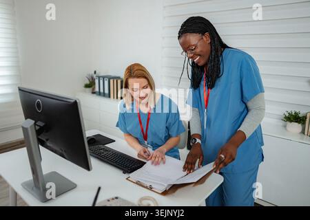 Healthcare professionals collaborating on patient records in clinic office Stock Photo