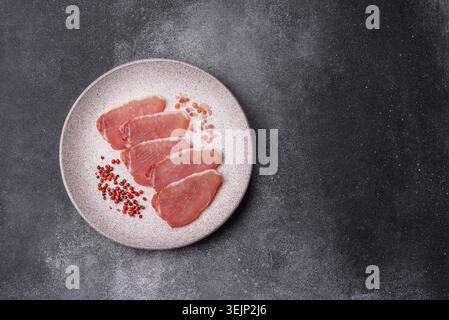 Smoked or dry cured meat slices, pork or ham with salt and spices. Smoked meat slices Stock Photo
