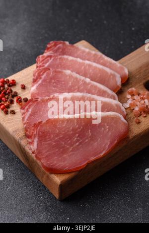 Smoked or dry cured meat slices, pork or ham with salt and spices. Smoked meat slices Stock Photo