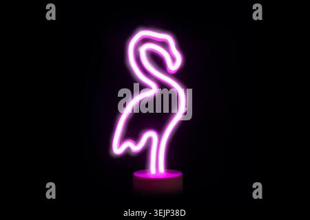Neon pink flamingo LED lamp isolated on black. Stock Photo