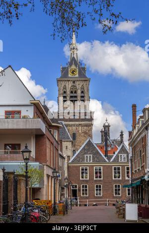 Street view in Delft, Netherlands, towards the church. Historic brick architecture and stone paving under cloudy gray sky Stock Photo
