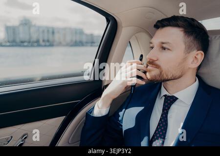 Serious company executive thinking of making serious decision while sitting in car Stock Photo