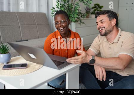 Smiling colleagues having a video call on a laptop at home Stock Photo