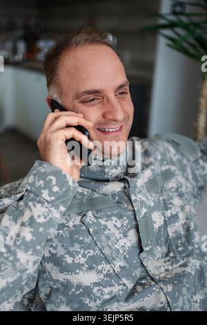 Happy military man talking on a smartphone Stock Photo