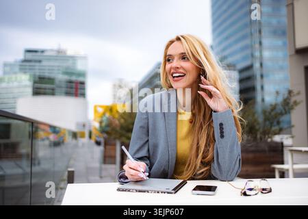Young businesswoman using drawing tablet outdoors in city Stock Photo