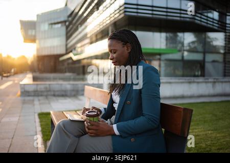 Businesswoman using digital tablet during urban coffee break Stock Photo