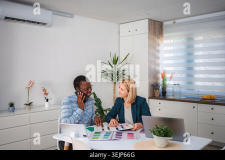 Interior designers discussing color swatches and collaborating on project Stock Photo