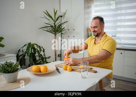 Man making fresh orange juice for healthy breakfast Stock Photo