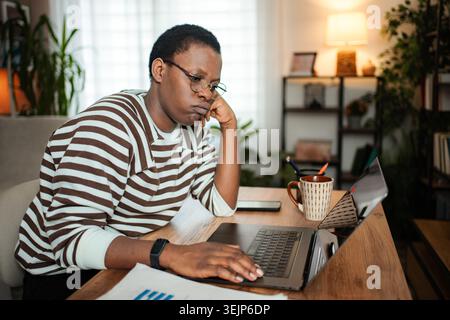 Frustrated young adult woman working from home feeling bored Stock Photo
