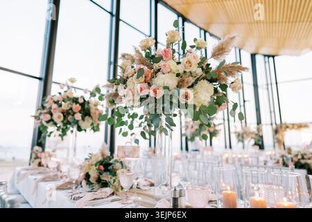 Elegant floral arrangement. Beautifully arranged rose display on glass table setting Stock Photo