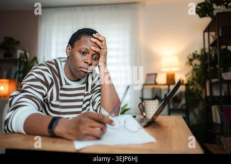 Young male adult feeling frustrated and stressed working from home Stock Photo