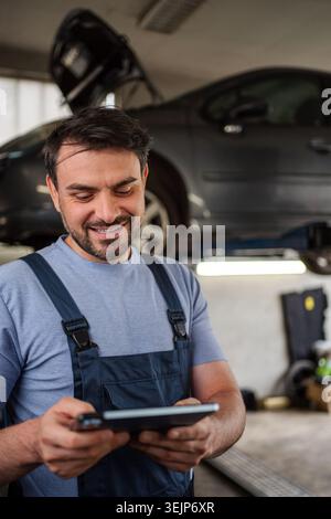 Car mechanic using a digital tablet in a workshop Stock Photo
