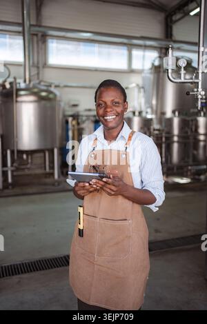 Black woman working in a brewery using digital tablet Stock Photo