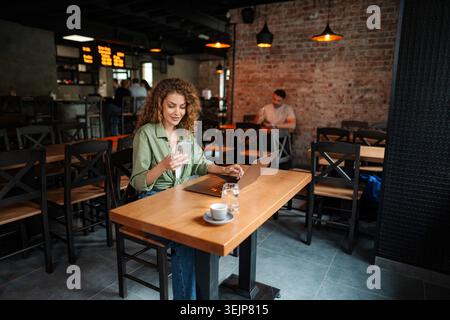 Freelancer is working at cafe using laptop and smartphone Stock Photo
