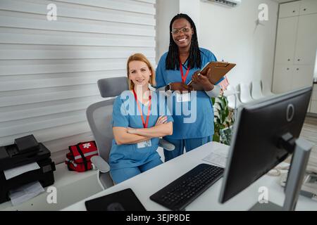Diverse nurses smiling at reception desk in a clinic Stock Photo