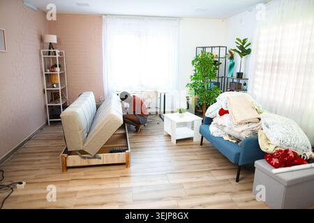Young man assembling sofa in new apartment Stock Photo