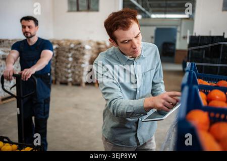 Quality control manager using digital tablet checking freshness Stock Photo