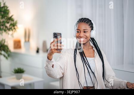 Young black woman wearing headphones having video call at home Stock Photo