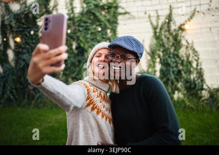 Diverse couple taking outdoor selfie enjoying happy moments Stock Photo