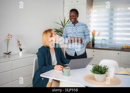 Diverse women colleagues collaborating remotely on business project at home Stock Photo