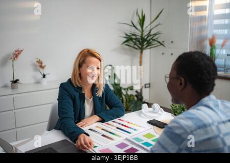 Interior designer woman consulting male client on color palette Stock Photo