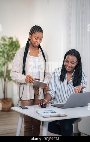 Two women collaborating on laptop and digital tablet Stock Photo