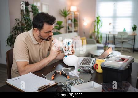 Technician assembling a smart home security camera at home Stock Photo