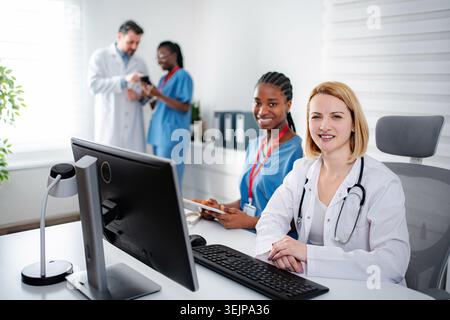 Medical professionals collaborating in hospital office using technology Stock Photo