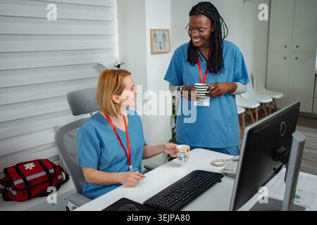 Healthcare professionals having coffee break and smiling in office Stock Photo
