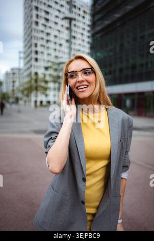 Young businesswoman talking on smartphone in urban setting Stock Photo
