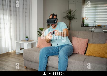 Man playing virtual reality video game at home Stock Photo