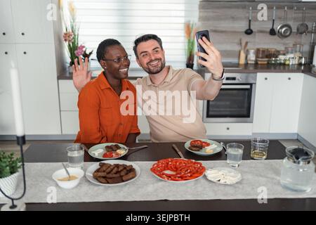 Happy Couple Taking a Selfie While Having Breakfast in the Kitchen Stock Photo
