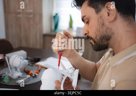 Technician assembling cctv camera at his desk Stock Photo