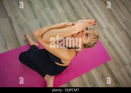 Practicing an advanced yoga pose in a calm indoor studio space Stock Photo