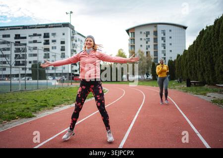 Young women exercising outdoors on running track Stock Photo